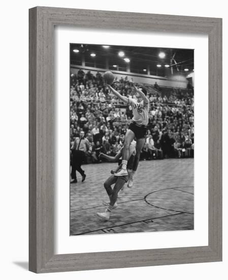 Basketball Player Tom Gola Leaping in the Air to Make a Shot During a Basketball Game-null-Framed Photographic Print