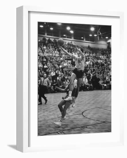 Basketball Player Tom Gola Leaping in the Air to Make a Shot During a Basketball Game-null-Framed Photographic Print