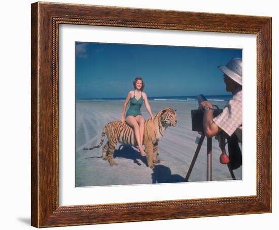 Bathing Beauty Sitting on Back of Large Tiger on Beach as Photographer Sets Up Camera-Eliot Elisofon-Framed Photographic Print