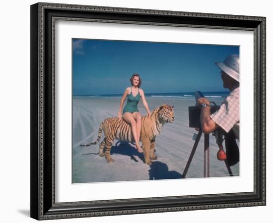 Bathing Beauty Sitting on Back of Large Tiger on Beach as Photographer Sets Up Camera-Eliot Elisofon-Framed Photographic Print