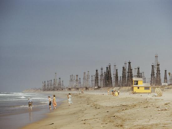 beach scene with oil rigs in the background photographic print by