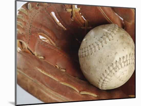 Beaten-Up Baseball in Baseball Glove-null-Mounted Photographic Print