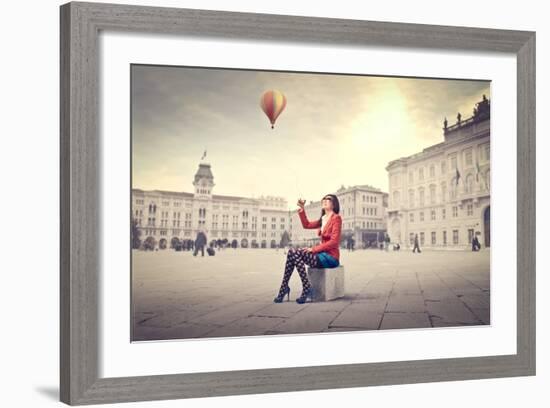 Beautiful Woman In Colored Clothes On A Square With Hot-Air Balloon In The Background-olly2-Framed Art Print