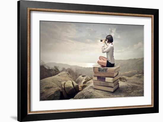 Beautiful Woman Sitting On A Pile Of Old Books Watching With Binoculars-olly2-Framed Art Print