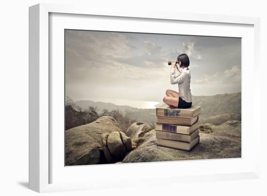 Beautiful Woman Sitting On A Pile Of Old Books Watching With Binoculars-olly2-Framed Art Print