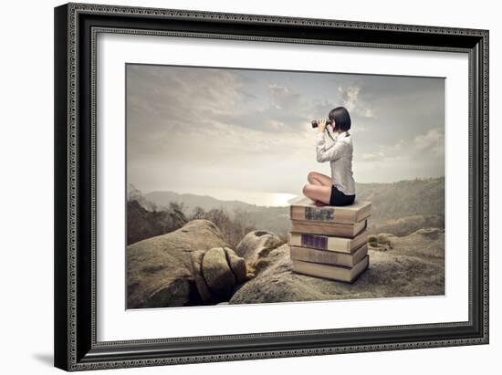 Beautiful Woman Sitting On A Pile Of Old Books Watching With Binoculars-olly2-Framed Art Print