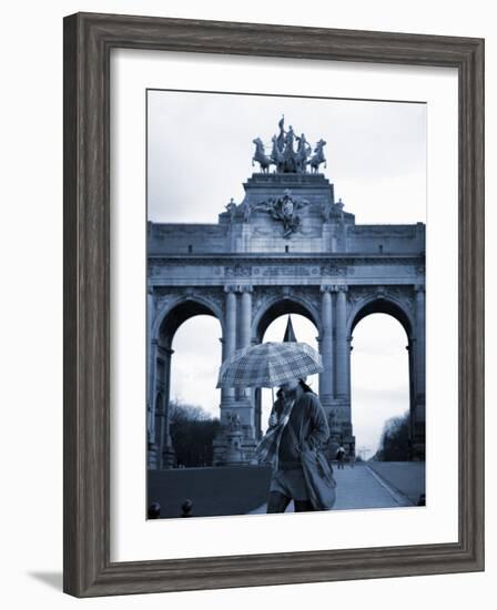 Belgium, Brussels; a Girl Walking with an Umbrella in Front of the Arc Du Triomphe-Ken Sciclina-Framed Photographic Print