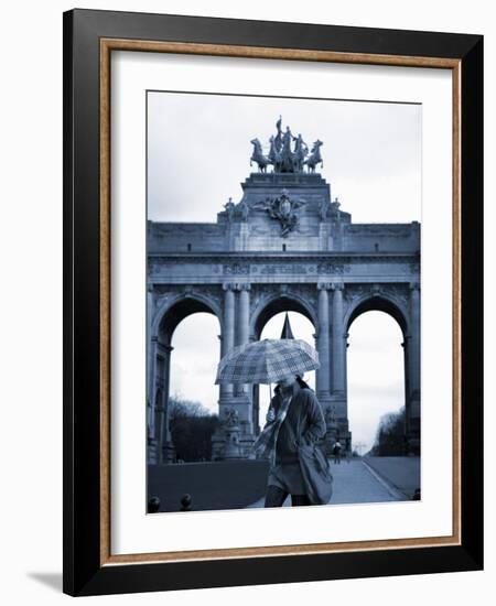 Belgium, Brussels; a Girl Walking with an Umbrella in Front of the Arc Du Triomphe-Ken Sciclina-Framed Photographic Print