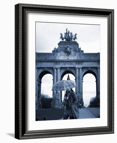 Belgium, Brussels; a Girl Walking with an Umbrella in Front of the Arc Du Triomphe-Ken Sciclina-Framed Photographic Print