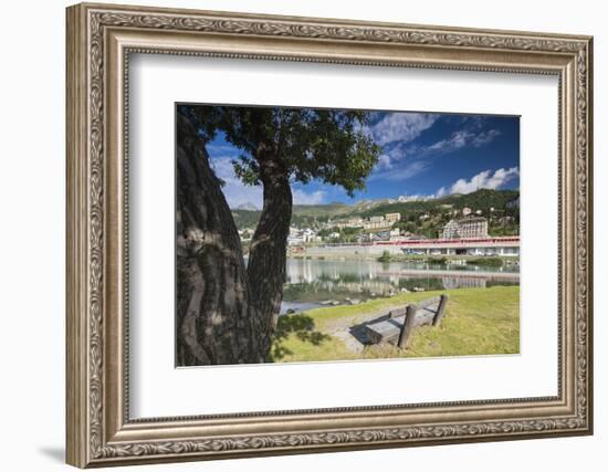 Bernina Express train runs past the village of St. Moritz surrounded by lake, Canton of Graubunden,-Roberto Moiola-Framed Photographic Print