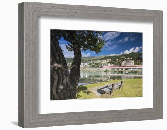 Bernina Express train runs past the village of St. Moritz surrounded by lake, Canton of Graubunden,-Roberto Moiola-Framed Photographic Print