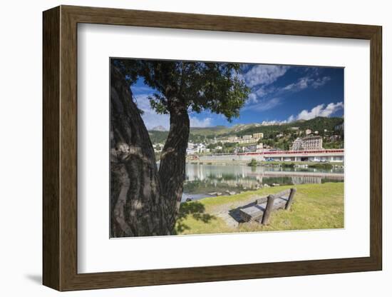 Bernina Express train runs past the village of St. Moritz surrounded by lake, Canton of Graubunden,-Roberto Moiola-Framed Photographic Print