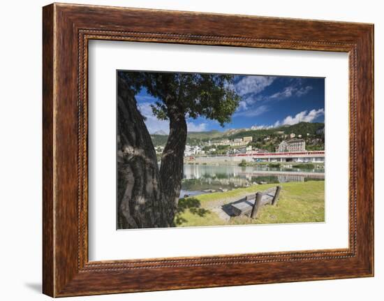 Bernina Express train runs past the village of St. Moritz surrounded by lake, Canton of Graubunden,-Roberto Moiola-Framed Photographic Print