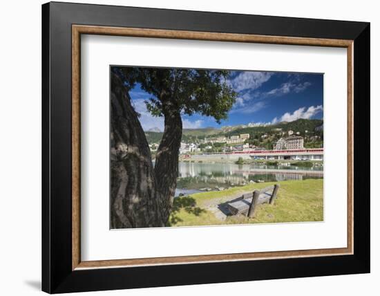 Bernina Express train runs past the village of St. Moritz surrounded by lake, Canton of Graubunden,-Roberto Moiola-Framed Photographic Print