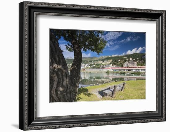 Bernina Express train runs past the village of St. Moritz surrounded by lake, Canton of Graubunden,-Roberto Moiola-Framed Photographic Print