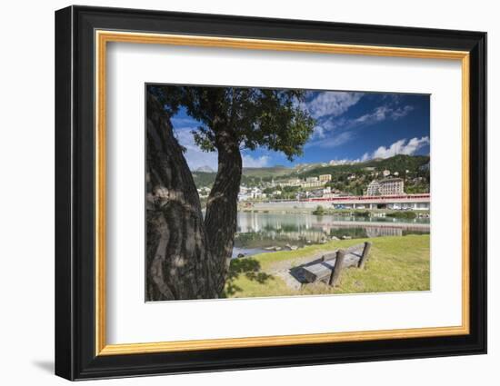 Bernina Express train runs past the village of St. Moritz surrounded by lake, Canton of Graubunden,-Roberto Moiola-Framed Photographic Print