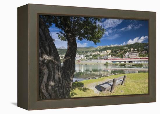 Bernina Express train runs past the village of St. Moritz surrounded by lake, Canton of Graubunden,-Roberto Moiola-Framed Premier Image Canvas