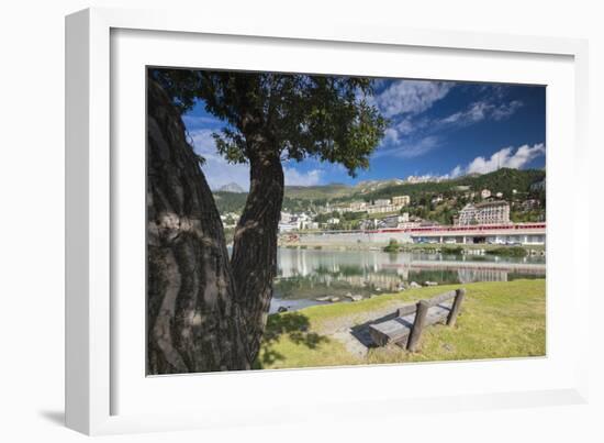 Bernina Express train runs past the village of St. Moritz surrounded by lake, Canton of Graubunden,-Roberto Moiola-Framed Photographic Print