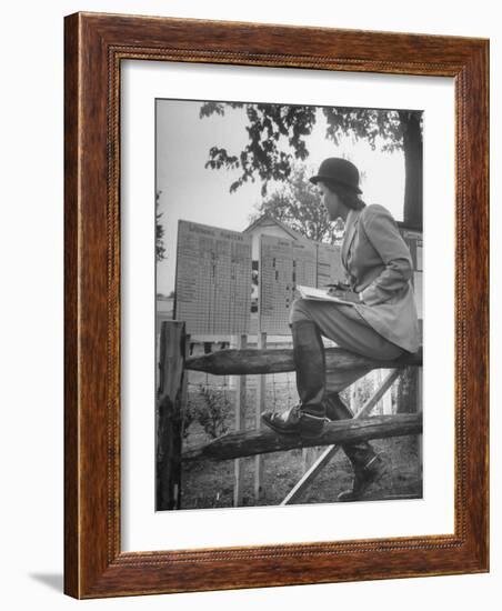 Betty Jane Baldwin Sitting on Fence and Looking at Official Board at Warrenton Horse Show-Martha Holmes-Framed Photographic Print