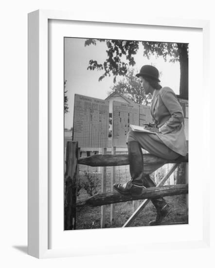 Betty Jane Baldwin Sitting on Fence and Looking at Official Board at Warrenton Horse Show-Martha Holmes-Framed Photographic Print