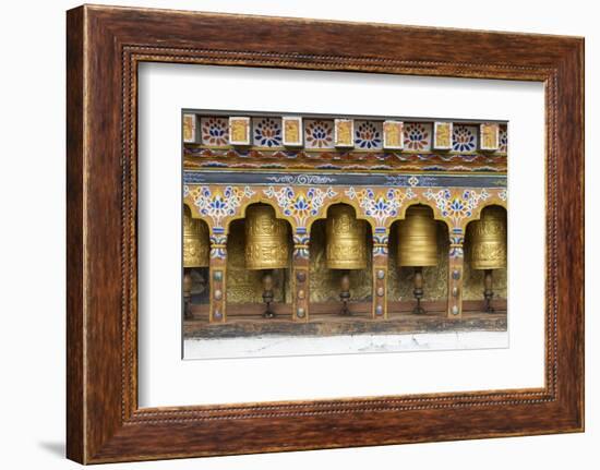 Bhutan. Spinning prayer wheels along a temple wall.-Brenda Tharp-Framed Photographic Print