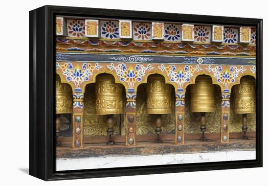 Bhutan. Spinning prayer wheels along a temple wall.-Brenda Tharp-Framed Premier Image Canvas