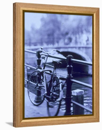 Bicycle on Rail by Canal, Amsterdam, Netherlands-Walter Bibikow-Framed Premier Image Canvas