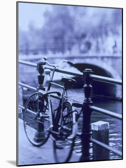 Bicycle on Rail by Canal, Amsterdam, Netherlands-Walter Bibikow-Mounted Photographic Print