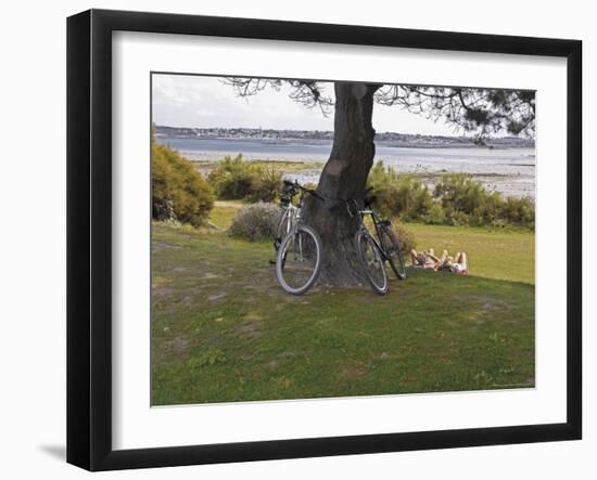 Bicycles by Tree and Couple Relaxing on the Grass, St. Pol De Leon, Carentac in Distance, Brittany-David Hughes-Framed Photographic Print