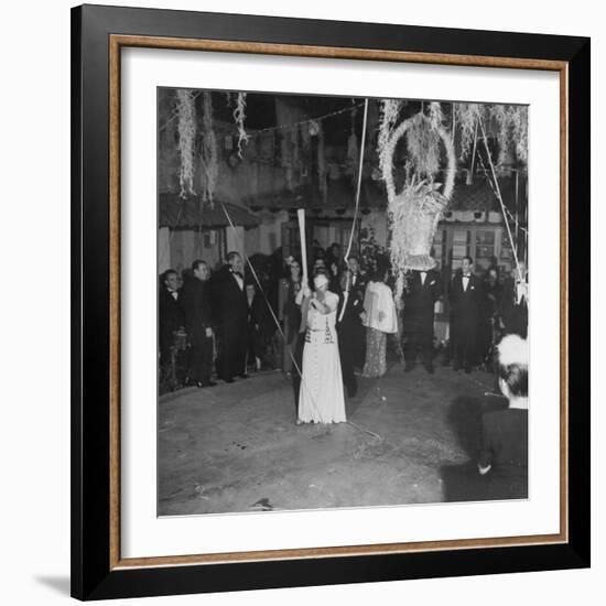 Blind Folded Woman Trying to Split Open the Pinata, During Traditional Pre-Christmas Celebration-Ed Clark-Framed Photographic Print