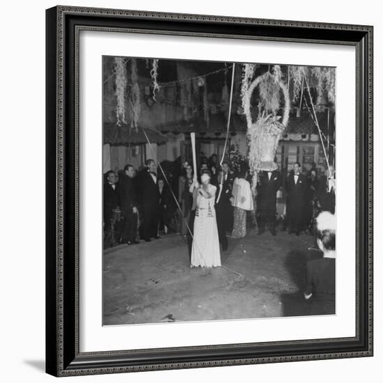 Blind Folded Woman Trying to Split Open the Pinata, During Traditional Pre-Christmas Celebration-Ed Clark-Framed Photographic Print