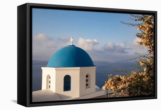 Blue domed Greek Orthodox church with bougainvillea flowers in Oia, Santorini, Greece.-Michele Niles-Framed Premier Image Canvas