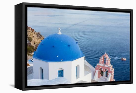 Blue domed white church overlooking boat in Aegean Sea, Santorini, Cyclades-Ed Hasler-Framed Premier Image Canvas