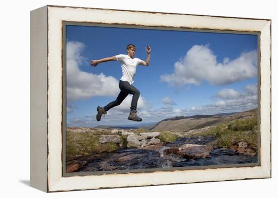 Boy (Aged 17) Jumping across Upland Stream-Mark Hamblin-Framed Premier Image Canvas