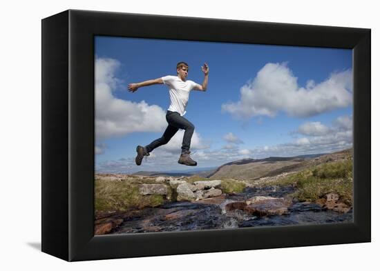 Boy (Aged 17) Jumping across Upland Stream-Mark Hamblin-Framed Premier Image Canvas