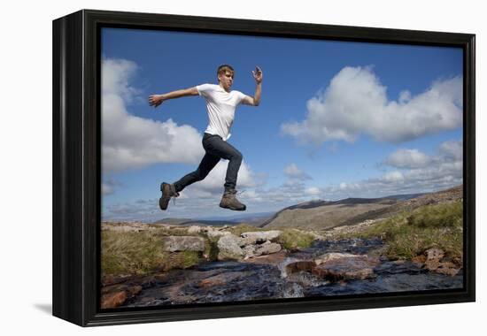 Boy (Aged 17) Jumping across Upland Stream-Mark Hamblin-Framed Premier Image Canvas