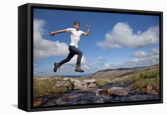 Boy (Aged 17) Jumping across Upland Stream-Mark Hamblin-Framed Premier Image Canvas