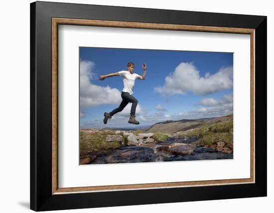 Boy (Aged 17) Jumping across Upland Stream-Mark Hamblin-Framed Photographic Print