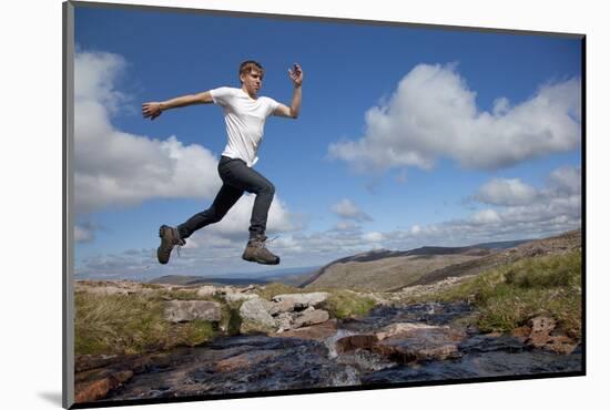 Boy (Aged 17) Jumping across Upland Stream-Mark Hamblin-Mounted Photographic Print