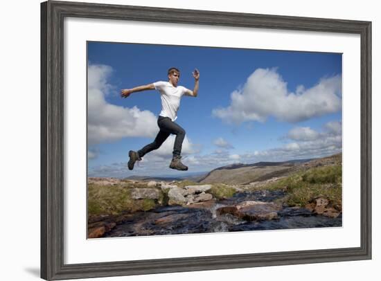 Boy (Aged 17) Jumping across Upland Stream-Mark Hamblin-Framed Photographic Print