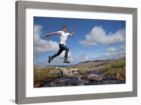 Boy (Aged 17) Jumping across Upland Stream-Mark Hamblin-Framed Photographic Print