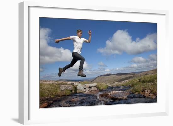 Boy (Aged 17) Jumping across Upland Stream-Mark Hamblin-Framed Photographic Print