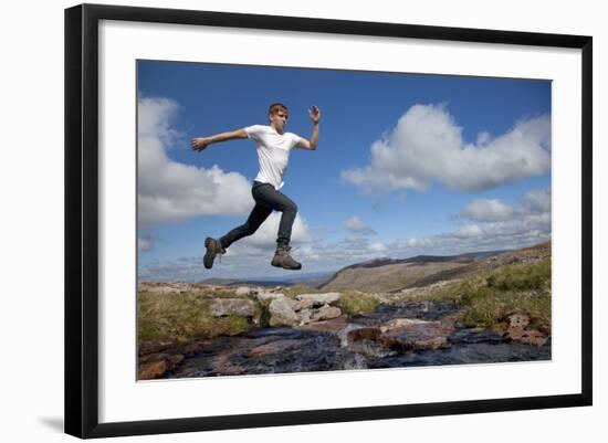 Boy (Aged 17) Jumping across Upland Stream-Mark Hamblin-Framed Photographic Print