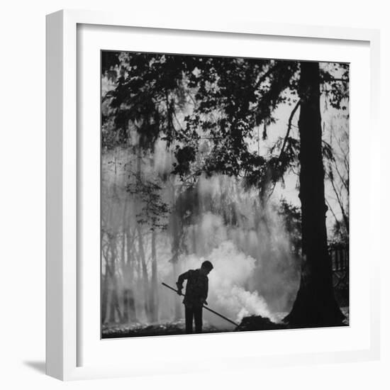 Boy Combining Play and Seasonal Chore, Stirring a Pile of Burning Leaves-Allan Grant-Framed Photographic Print