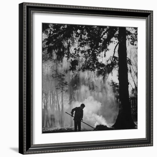 Boy Combining Play and Seasonal Chore, Stirring a Pile of Burning Leaves-Allan Grant-Framed Photographic Print