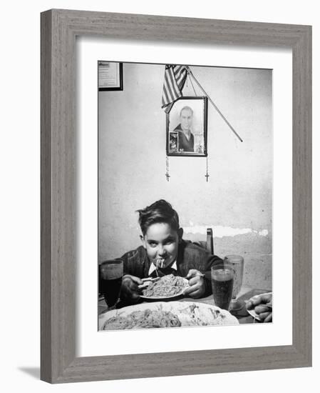 Boy Eating Spaghetti under Picture of His Brother Who Died During Invasion of Sicily-null-Framed Photographic Print