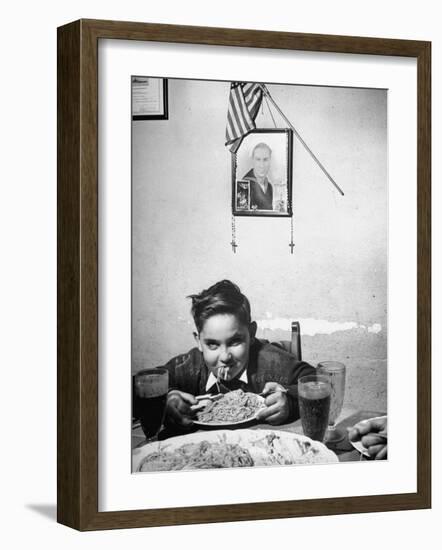 Boy Eating Spaghetti under Picture of His Brother Who Died During Invasion of Sicily-null-Framed Photographic Print