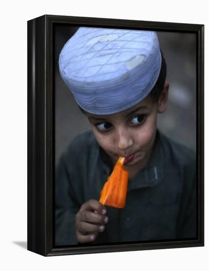 Boy Eats an Ice Lolly in a Neighborhood on the Outskirts of Islamabad, Pakistan-null-Framed Premier Image Canvas