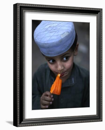 Boy Eats an Ice Lolly in a Neighborhood on the Outskirts of Islamabad, Pakistan-null-Framed Photographic Print