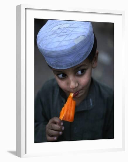 Boy Eats an Ice Lolly in a Neighborhood on the Outskirts of Islamabad, Pakistan-null-Framed Photographic Print